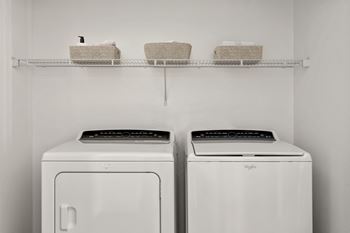 Two white front loading washing machines in a laundry room.
